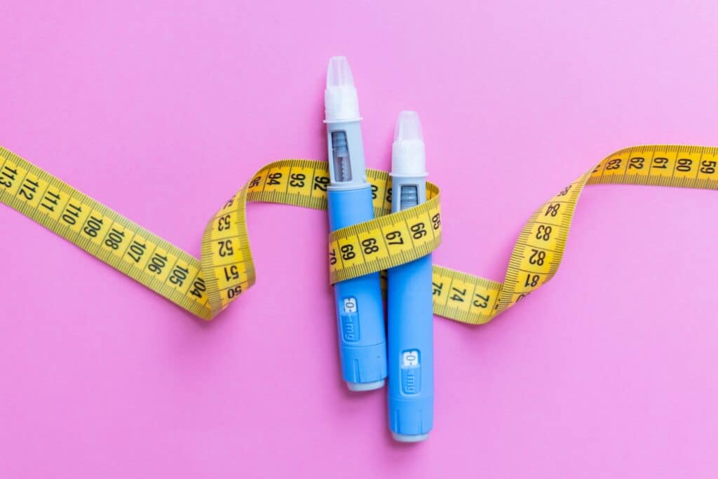 Medical pens for Ozempic therapy on pink background; Liposuction or Ozempic for Weight Loss?